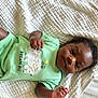 Asher joined the competition — help win amazing prizes! baby, infant, child, onesie, green_clothing, smile, face, hand, blanket, texture, lying_down, cute, sleepwear, portrait, indoors, soft_light, skin, curly_hair, young_child, resting
