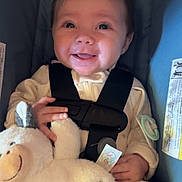 Amelia Rose is registered to the contest to win money with this photo: baby, smile, car_seat, stuffed_animal, plush_toy, child, safety_harness, bow, happy, cute, infant, hand, clothing, seat, indoor, face, portrait, soft_toy, comfort, childcare