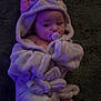 Amelia Rose is registered to the contest to win money with this photo: baby, infant, pacifier, robe, unicorn, hood, pink, purple_light, soft_fabric, lying_down, cute, child, indoors, carpet, foot, face, expression, sleepwear, cozy, adorable