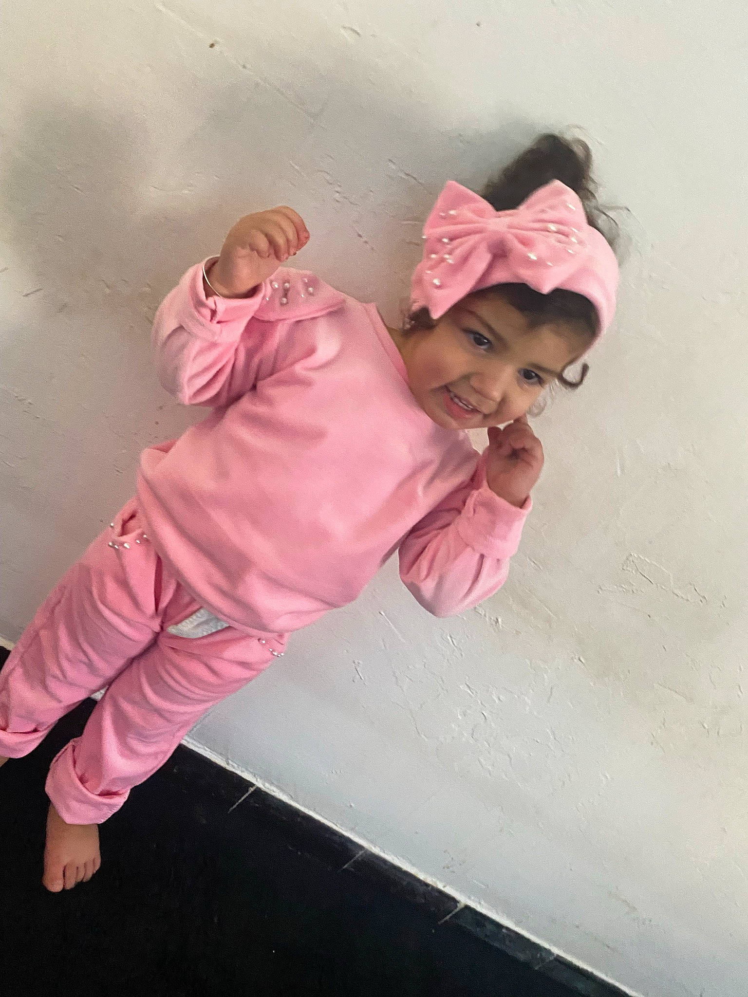 Maria a rejoint le concours — aidez-le/la à gagner de superbes lots ! baby, baby_toddler_clothing, child, comfort, flooring, fun, happy, headwear, joy, linens, magenta, paper_product, peach, person, pink, room, sitting, sleeve, toddler