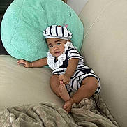 Tikena participe au concours pour gagner de l'argent avec cette photo : baby, blanket, child, comfortable, couch, cozy, curious, cute, furniture, hat, home, indoor, infant, person, pillow, portrait, relaxed, smiling, soft_texture, striped_clothing