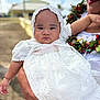 Tikena participe au concours pour gagner de l'argent avec cette photo : adult_hand, baby, background_blur, bonnet, celebration, child, clothing, face, family, happy, holding, lace, nature, outdoor, person, portrait, serious_expression, sky, sunlight, white_dress