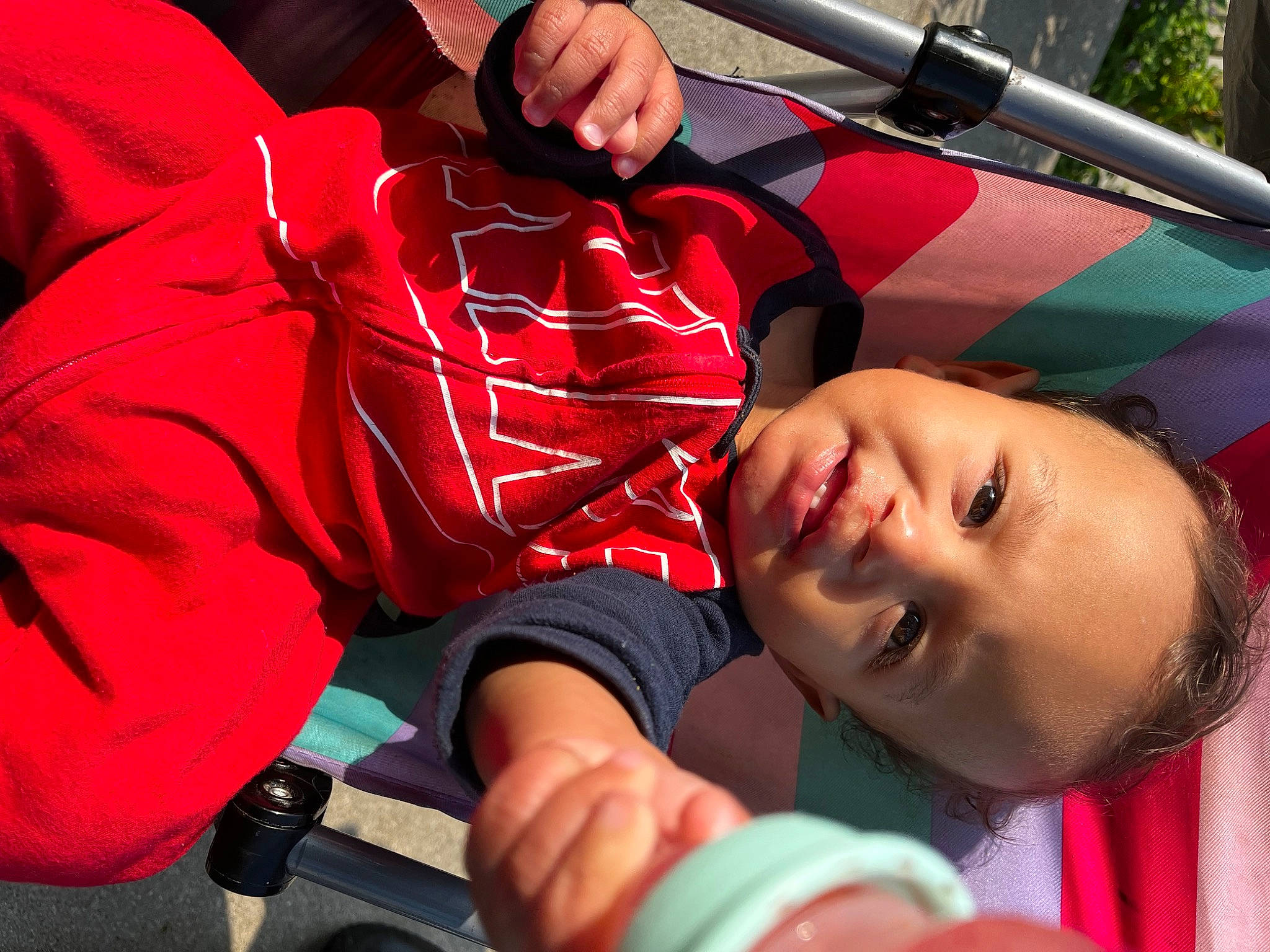 Keith is registered to the contest to win money with this photo: baby, baby_products, carmine, child, electric_blue, fun, grass, hand, happy, leisure, magenta, mouth, person, personal_protective_equipment, play, recreation, red, skin, smile, toddler