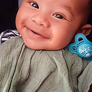 Uriel participe au concours pour gagner de l'argent avec cette photo : baby, smiling, face, blanket, pacifier, infant, child, cute, happy, portrait, closeup, skin, clothing, hand, expression, indoors, person, head, cheeks, eyes