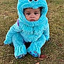 Zamarii is registered to the contest to win money with this photo: toddler, child, costume, monster, blue, outdoor, grass, cute, face, hood, horns, clothing, expression, sitting, feet, toy_like, playful, nature, young, portrait