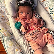 Royalty joined the competition — help win amazing prizes! baby, infant, child, portrait, lying_down, headband, bow, pink_outfit, ruffles, pacifier, blanket, pillow, bedding, bassinet, cozy, indoors, wide_eyed, black_hair, patterned_fabric, sleepwear