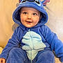 Louis a rejoint le concours — aidez-le/la à gagner de superbes lots ! baby, blue_costume, hood, plush, smiling, sitting, indoor, child, cute, face, eyes, happy, comfort, couch, soft, person, infant, apparel, cozy, portrait