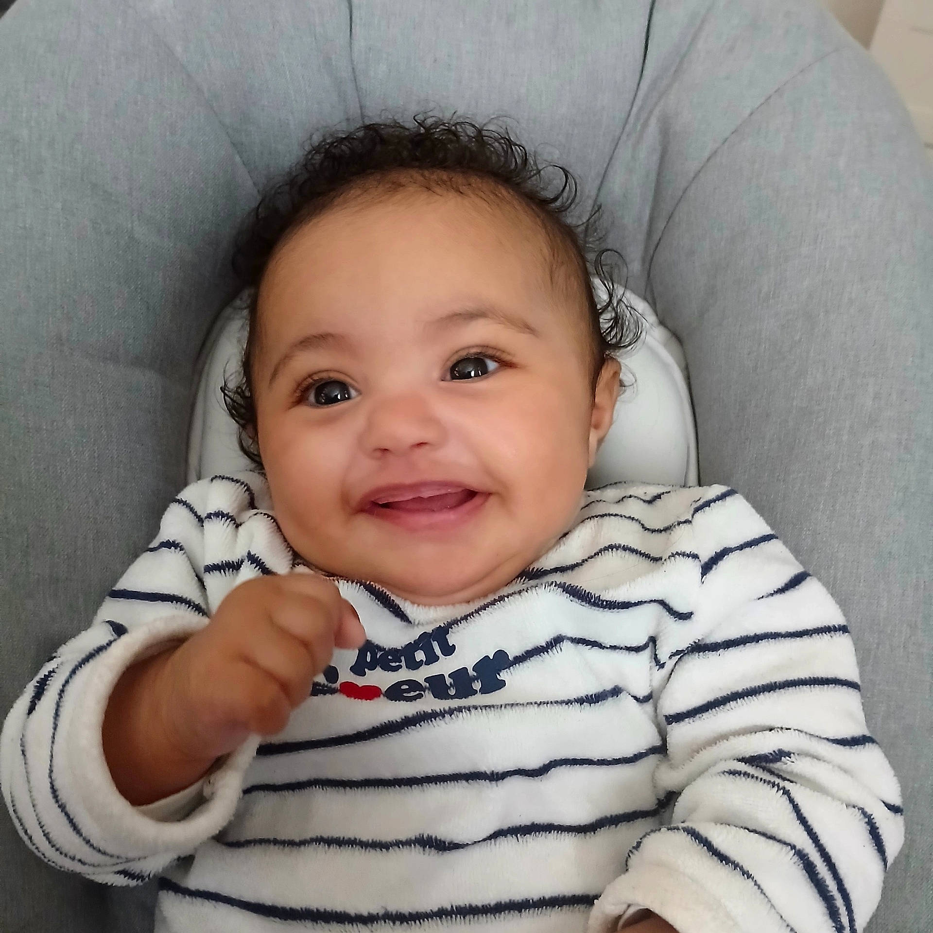 Zadéony a rejoint le concours — aidez-le/la à gagner de superbes lots ! baby, chair, child, closeup, curly_hair, cute, face, gray_chair, hand, happy, indoor, infant, joyful, navy_stripes, portrait, sitting, smiling, striped_clothing, white_clothing, young_child