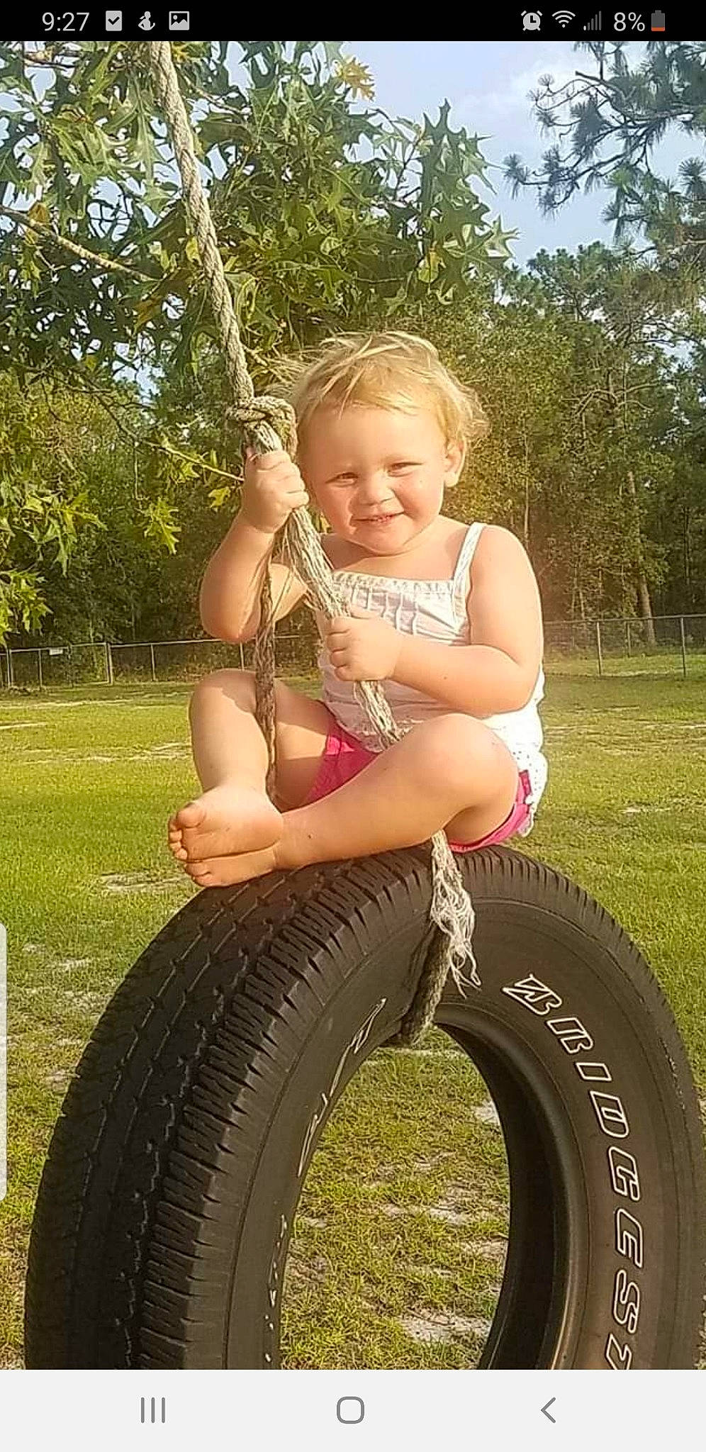 Braylin joined the competition — help win amazing prizes! automotive_tire, automotive_wheel_system, blond, child, grass, joy, outdoor_play_equipment, person, play, smile, swing, tire, toddler, tree
