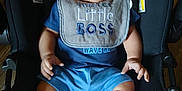 Zayden joined the competition — help win amazing prizes! baby, child, car_seat, bib, blue_clothing, white_socks, sitting, indoors, infant, cute, portrait, young_child, seat, hands, legs, footwear, fabric, warning_label, expression, person