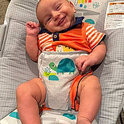 Hudson joined the competition — help win amazing prizes! baby, infant, child, smiling, happy, portrait, close_up, face, eyes, indoor, bouncer, baby_seat, colorful, rainbow, monkey, elephant, toy, orange_clothing, striped_shirt, bare_feet