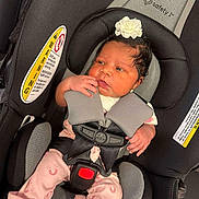 Za'Niyah Washington joined the competition — help win amazing prizes! baby, baby_clothes, baby_girl, car_interior, car_seat, child, clothing, cute, flower_headband, headwear, indoors, infant, newborn, person, pink_pajamas, portrait, resting, safety_harness, seat_belt, young_child