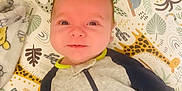 Gus is registered to the contest to win money with this photo: animal_print, baby, blanket, child, colorful, comfortable, cute, giraffe, happy, hedgehog, indoors, infant, koala, lying_down, onesie, pattern, playmat, portrait, smiling, soft