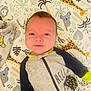 animal_print, baby, blanket, child, colorful, comfortable, cute, giraffe, happy, hedgehog, indoors, infant, koala, lying_down, onesie, pattern, playmat, portrait, smiling, soft