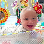 Dougie is registered to the contest to win money with this photo: baby, smiling, playmat, toy, colorful, infant, face, happy, child, indoor, cute, babyclothes, softtoys, mesh, pattern, head, bright, fun, toddler, playtime
