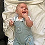 baby, infant, smiling, overalls, clothing, peter_rabbit, blanket, soft_texture, happy, cute, face, hand, fingers, lying_down, indoor, child, light_blue, white, comfort, couch