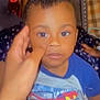 Jahmir is registered to the contest to win money with this photo: affection, blue_shirt, blurred_background, car_print, casual_clothing, cheek, child, closeup, curly_hair, expressionless, face, hand, indoor, patterned_fabric, person, playing, portrait, seated, shirt, young_child