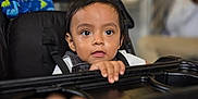 Lucas joined the competition — help win amazing prizes! toddler, child, stroller, baby, curious, indoor, hand, face, black_hair, clothing, seat, grip, tray, person, infant, portrait, expression, blurred_background, cute, young