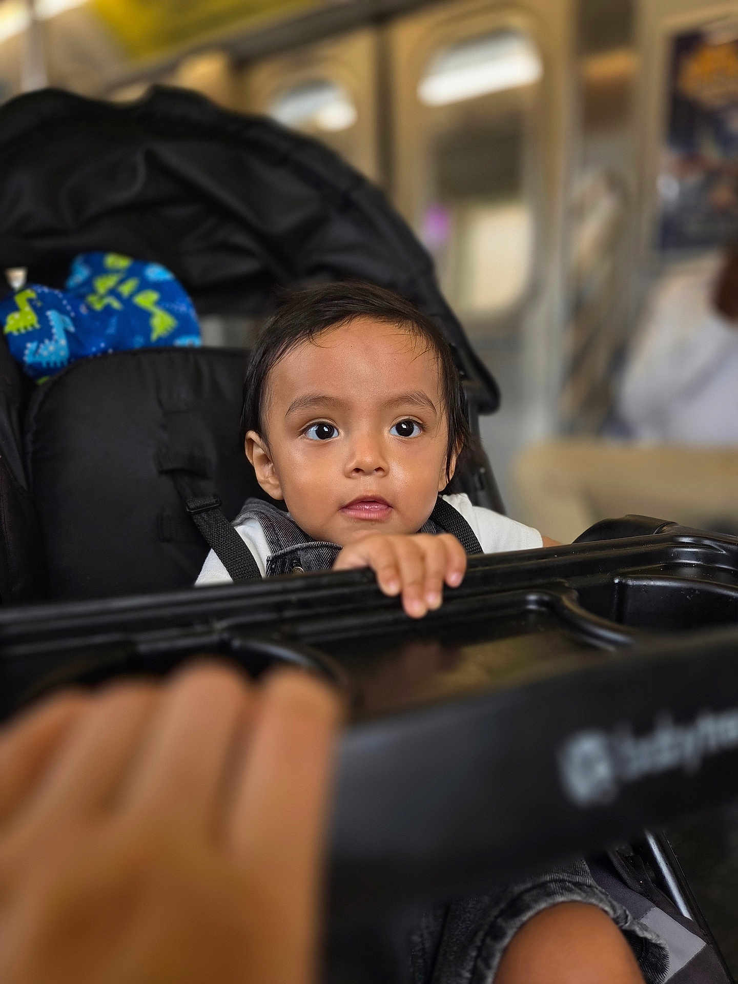 Lucas joined the competition — help win amazing prizes! toddler, child, stroller, baby, curious, indoor, hand, face, black_hair, clothing, seat, grip, tray, person, infant, portrait, expression, blurred_background, cute, young