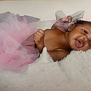 Marlee joined the competition — help win amazing prizes! baby, infant, smile, pink_tutu, headband, fluffy_blanket, cute, portrait, child, happy, newborn, adorable, soft_texture, lying_down, skin, earrings, closeup, indoor, beauty, tulle