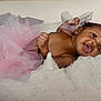 baby, infant, smile, pink_tutu, headband, fluffy_blanket, cute, portrait, child, happy, newborn, adorable, soft_texture, lying_down, skin, earrings, closeup, indoor, beauty, tulle