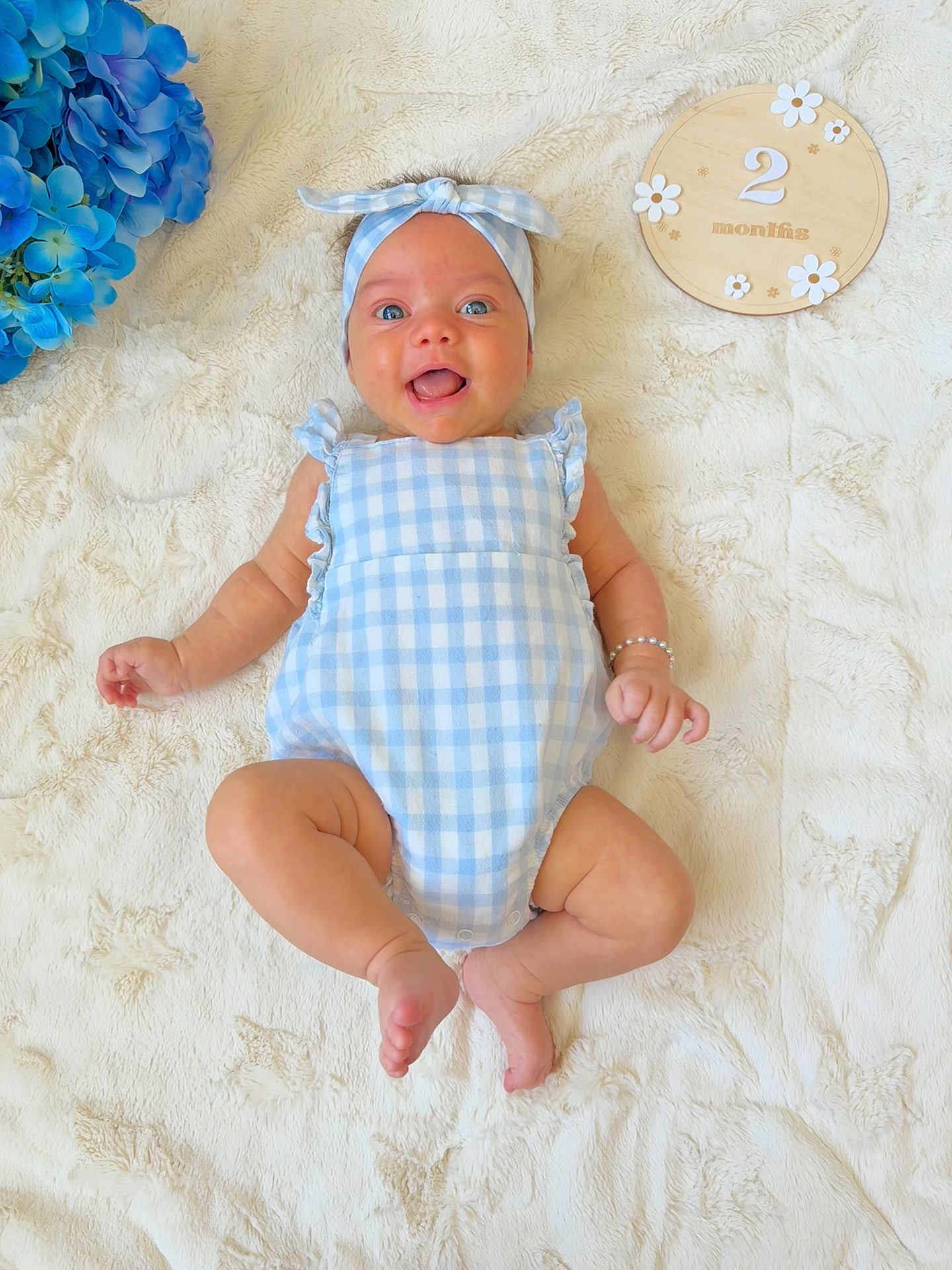 Belle joined the competition — help win amazing prizes! baby, infant, blue_outfit, headband, smiling, lying_down, blanket, plush, wooden_plaque, flowers, blue_flowers, milestone, two_months, cute, baby_bracelet, skin, happy, portrait, child, indoor