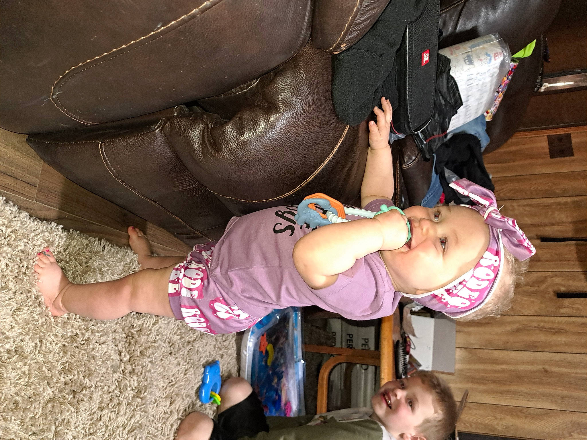 Heather is registered to the contest to win money with this photo: arm, baby, baby_toddler_clothing, child, eyewear, face, fun, hand, happy, hat, headwear, human_leg, joy, leather_jacket, leg, mouth, people, person, pink, thigh