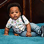 toddler, child, baby, indoor, bed, blanket, clothing, shirt, suspenders, jeans, shoes, footwear, curly_hair, portrait, face, expression, cute, looking, young, casual