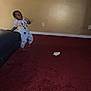 Javis C. Tie joined the competition — help win amazing prizes! toddler, child, pajamas, cartoon_characters, couch, carpet, indoor, wall, electrical_outlet, floor, motion_blur, expression, person, home, furniture, room, curious, leaning, barefoot, dim_lighting