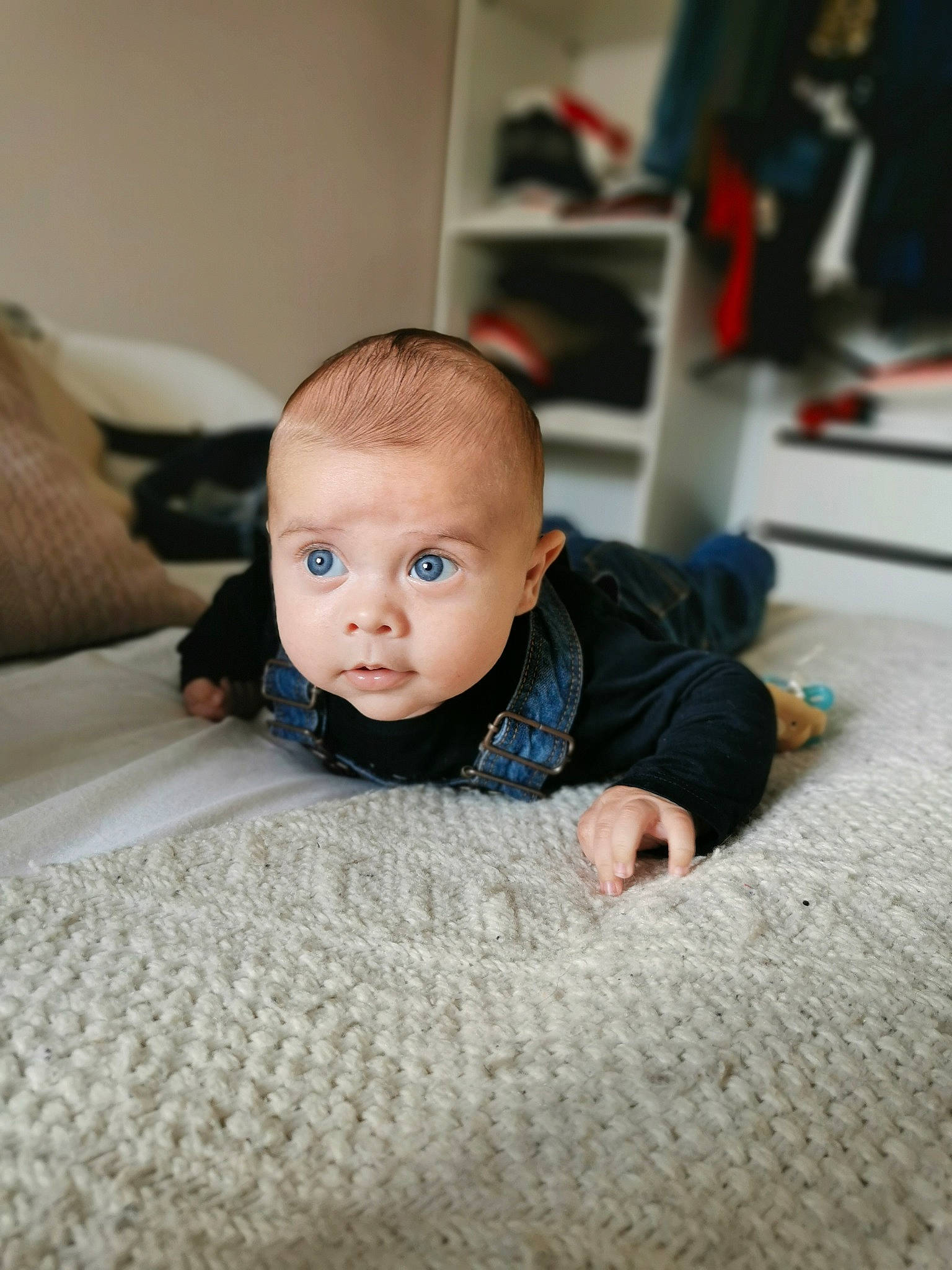 Émile participe au concours pour gagner de l'argent avec cette photo : baby, baby_toddler_clothing, carpet, cheek, child, comfort, crawling, eye, face, flash_photography, floor, flooring, fur, grey, hardwood, iris, linens, person, sitting, toddler
