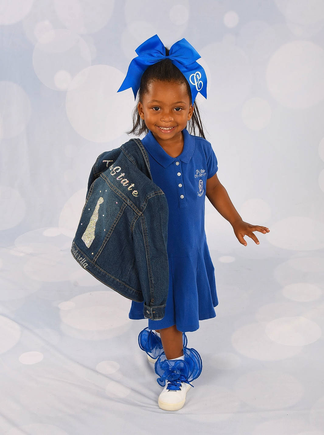 Ki'Aijah is registered to the contest to win money with this photo: academic_dress, blue, child, costume, electric_blue, event, face, fashion_accessory, fashion_design, fun, gesture, glove, happy, hat, joy, mortarboard, person, recreation, sleeve, smile