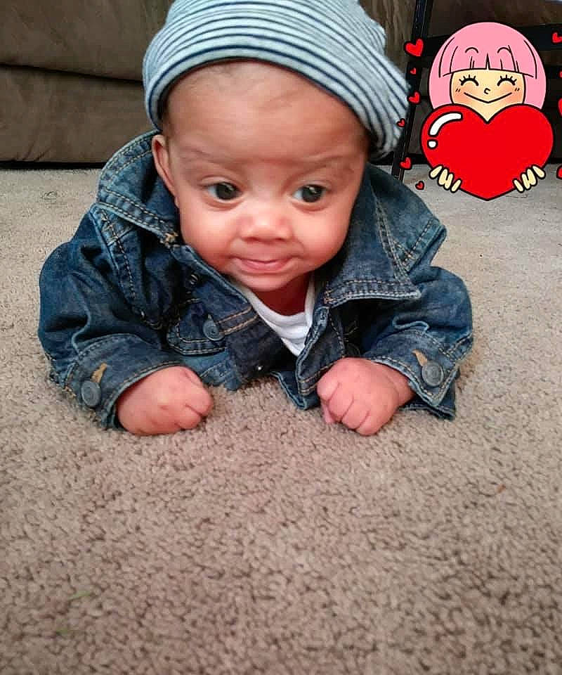 Kareem is registered to the contest to win money with this photo: baby, baby_toddler_clothing, beanie, cap, cheek, child, comfort, flooring, grass, headwear, knit_cap, lip, nose, outerwear, person, sitting, skin, sleeve, thumb, toddler