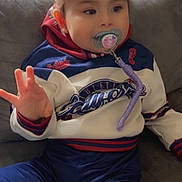 Zeynep participe au concours pour gagner de l'argent avec cette photo : blue, casual, child, clothing, comfort, couch, expression, face, furniture, hand, hoodie, indoor, pacifier, person, purple, red, sitting, toddler, white, young_child