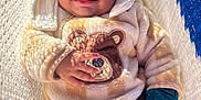 Kenaz is registered to the contest to win money with this photo: baby, child, smiling, tongue_out, hooded_clothing, bear_design, onesie, hammock, knit_texture, sunlight, shadow, cozy, cute, infant, happy, outdoor, soft_clothing, portrait, relaxed, playful