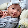 Kehlani is registered to the contest to win money with this photo: baby, blanket, bow, closeup, cute, face, flower, gentle, hand, headband, indoors, infant, lying_down, newborn, peaceful, portrait, skin, smile, soft_texture, white_flower