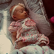 Ivory is registered to the contest to win money with this photo: baby, newborn, sleeping, headband, floral_outfit, blanket, cushion, infant, cute, cozy, pink, child, soft, resting, indoors, clothing, peaceful, portrait, baby_seat, closeup
