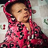 baby, infant, child, face, expression, robe, pink, leopard_print, pattern, blanket, fruit_pattern, strawberries, cherries, fabric, indoor, portrait, cute, wrapped, cozy, person