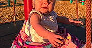 Mia joined the competition — help win amazing prizes! baby, blanket, child, clothing, cute, daylight, greenery, happy, infant, nature, outdoor, park, play, playground, reaching_hand, red_pole, rope, sunlight, swing, woodchips