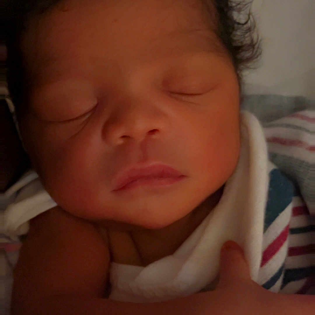 Chosen is registered to the contest to win money with this photo: newborn, baby, sleeping, blanket, curly_hair, infant, soft_lighting, peaceful, wrapped, close_up, portrait, skin, child, cute, tiny, resting, indoors, warm, comfort, face