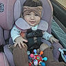 baby, infant, child, car_seat, vehicle, headband, bow, pink, portrait, face, eyes, smiling, clothing, onesie, socks, toy, colorful, harness, seated, indoor