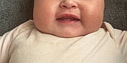Gracie-May is registered to the contest to win money with this photo: baby, infant, smile, face, cheeks, onesie, cushion, indoor, child, happy, portrait, skin, head, person, young, cute, closeup, seated, cozy, expression