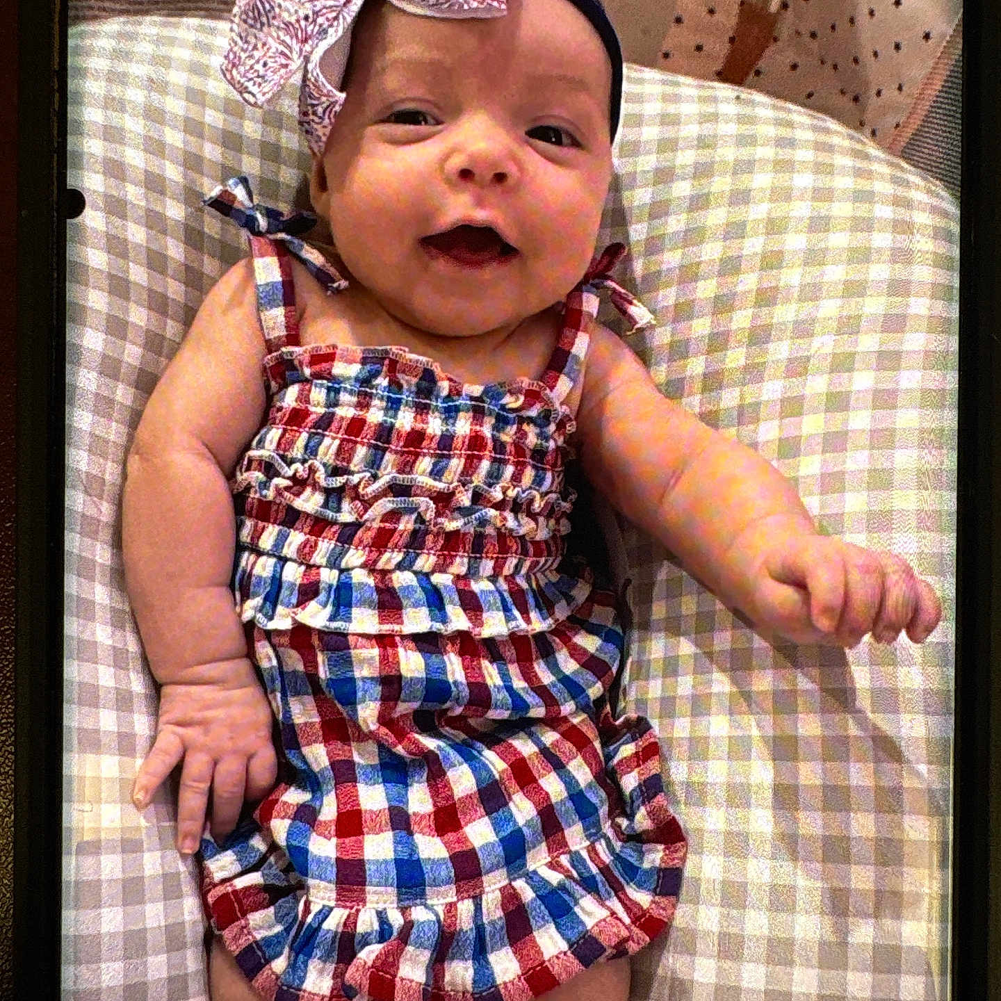 Delilah P. joined the competition — help win amazing prizes! baby, baby_girl, bow, checked_pattern, child, closeup, clothing, cushion, cute, dress, happy, headband, indoors, infant, person, portrait, resting, skin, smiling, young