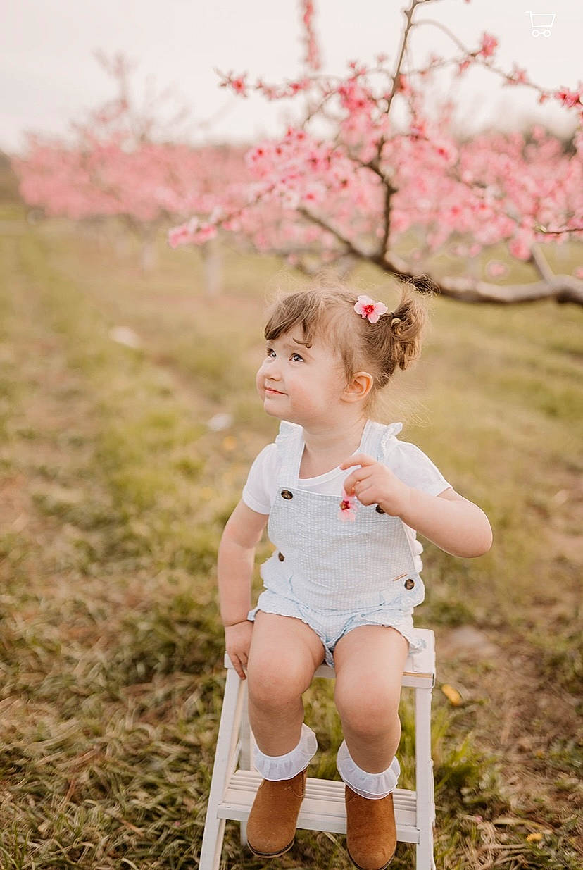 Thea is registered to the contest to win money with this photo: baby, blossom, flash_photography, flower, grass, grassland, happy, human_leg, joy, leg, leisure, meadow, people_in_nature, person, petal, pink, plant, portrait_photography, recreation, toddler