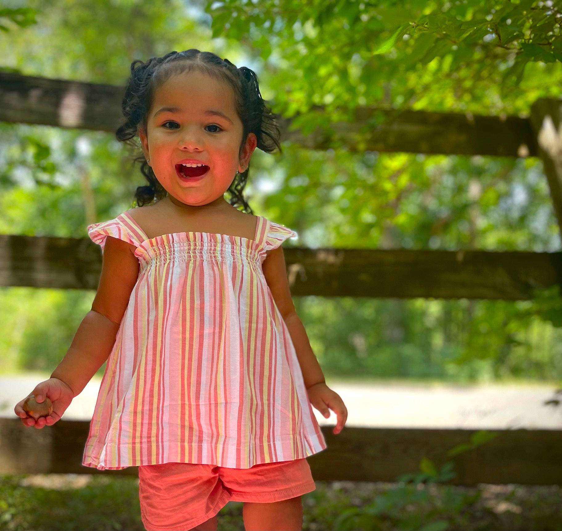 Alessandra is registered to the contest to win money with this photo: baby_toddler_clothing, clothing, day_dress, face, grass, hair, happy, head, leisure, magenta, people_in_nature, person, pink, plant, skin, sleeve, smile, sunlight, toddler, waist