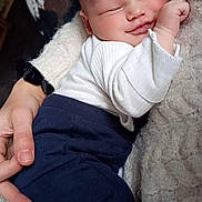 Arsène participe au concours pour gagner de l'argent avec cette photo : baby, blanket, blue_pants, closeup, clothing, comfort, cuddle, face, hand, head, indoor, infant, newborn, peaceful, person, rest, skin, sleeping, sock, white_shirt