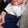 baby, blanket, blue_pants, closeup, clothing, comfort, cuddle, face, hand, head, indoor, infant, newborn, peaceful, person, rest, skin, sleeping, sock, white_shirt
