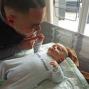 Arsène a rejoint le concours — aidez-le/la à gagner de superbes lots ! baby, man, indoor, window, table, clothing, face, interaction, portrait, changing_pad, furniture, human, expression, parent, child, love, care, home, daylight, gentle