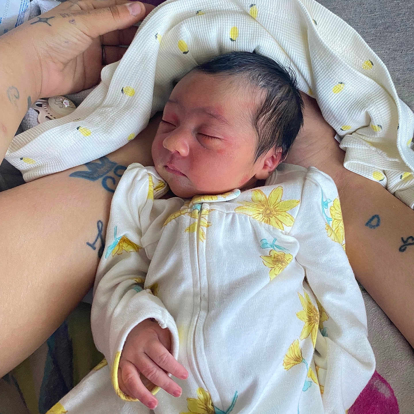 Kali is registered to the contest to win money with this photo: arm, baby, blanket, closeup, cozy, fabric, flower_pattern, gentle, hand, indoor, infant, newborn, onesie, peaceful, person, resting, skin, sleeping, soft_light, tattoo