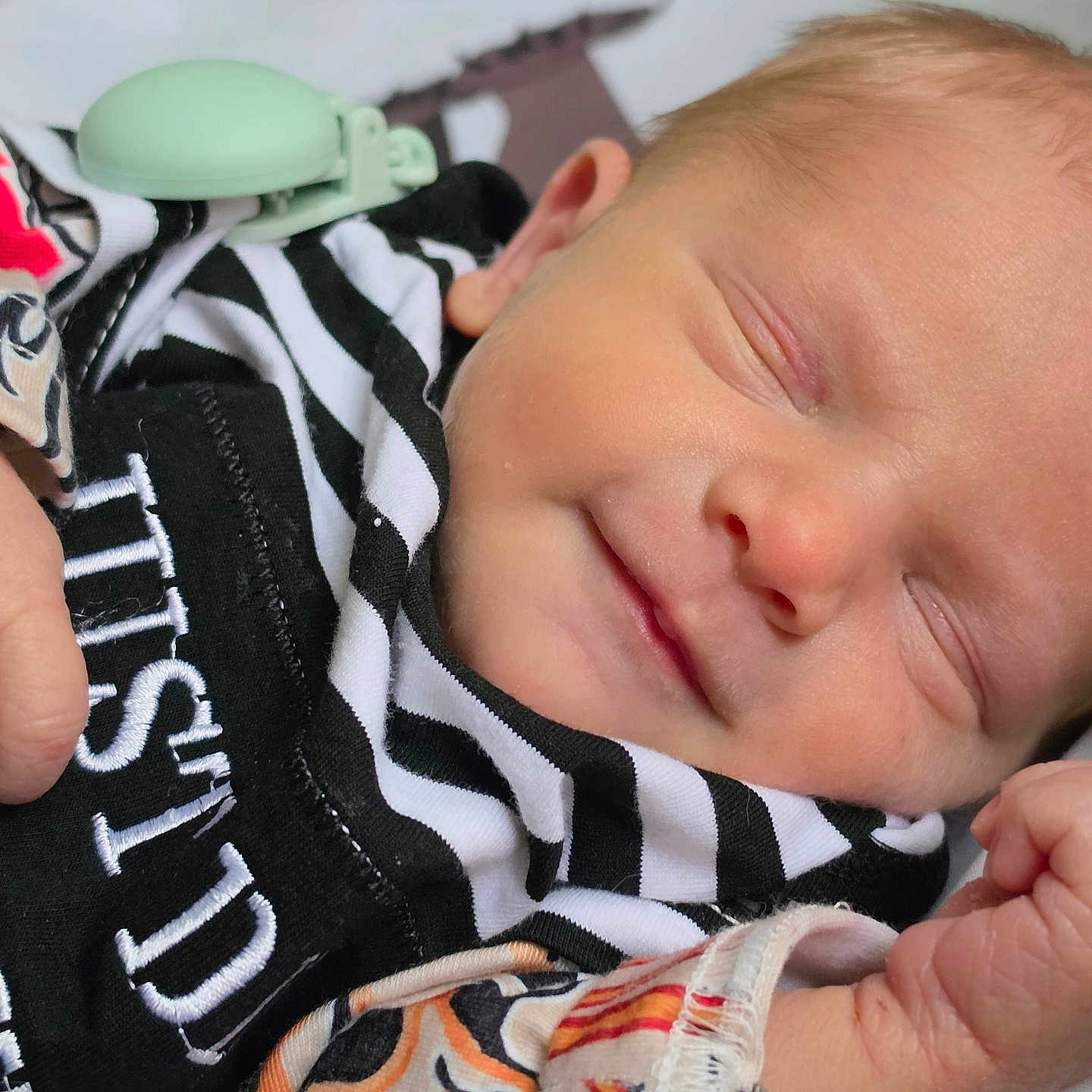 Gage is registered to the contest to win money with this photo: baby, newborn, sleeping, smile, face, hand, clothing, blanket, striped, patterned, infant, cute, peaceful, skin, fist, portrait, closeup, rest, soft, child