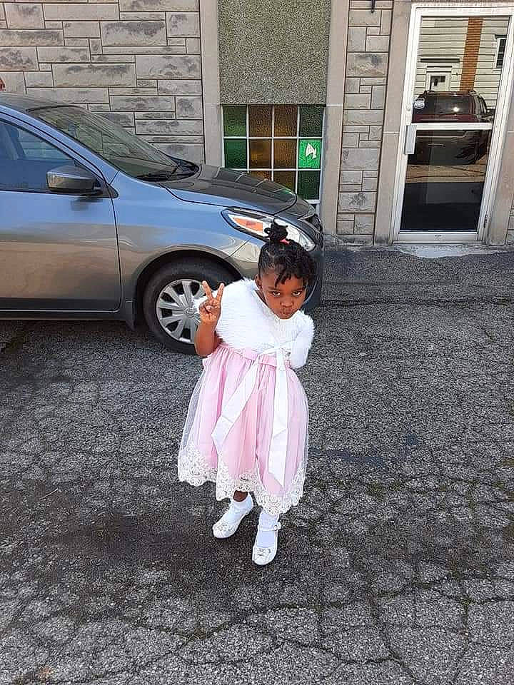 Cheyenne is registered to the contest to win money with this photo: asphalt, automotive_design, automotive_exterior, automotive_lighting, automotive_tire, automotive_wheel_system, building, car, door, dress, flooring, land_vehicle, motor_vehicle, person, street_fashion, tints_and_shades, tire, toddler, vehicle, vehicle_door